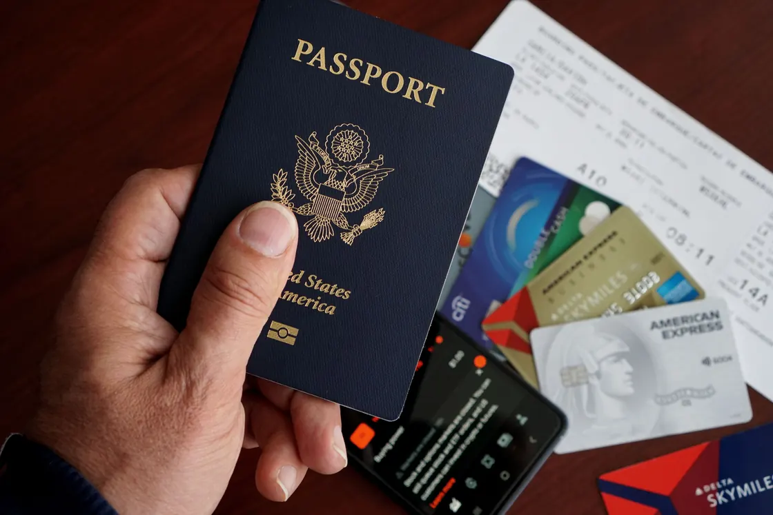 Un pasaporte estadounidense sobre una mesa junto a tarjetas y documentos de viaje.